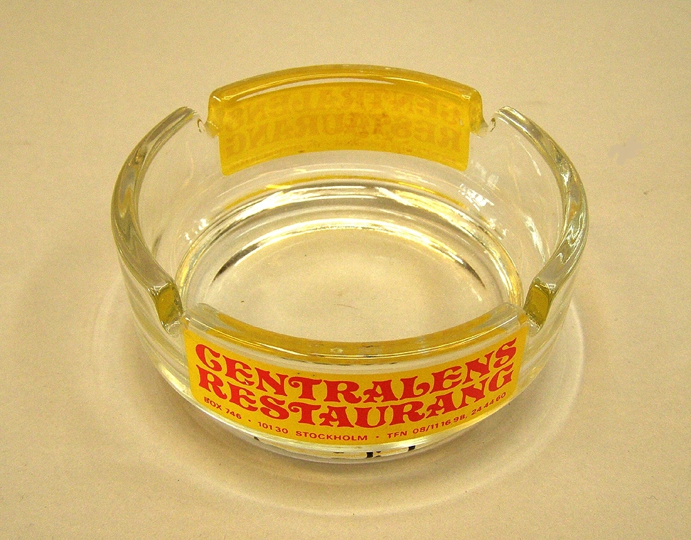 Askkopp av klart glas med tryck i gult och rött, från Centralens PUB och restaurang i Stockholm.