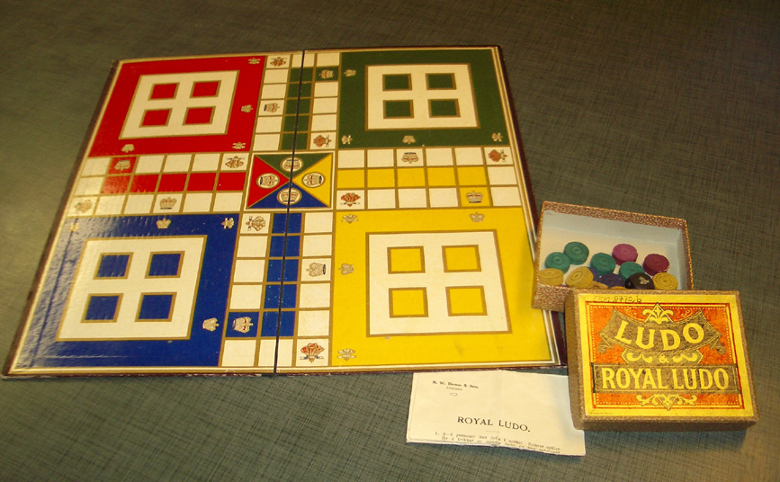 Ludospill som inneholder; (a) spillebrett, (b) eske med innhold: 4 røde, 4 gule, 4 blå, 4 grønne spillebrikker, fem terninger. 2 originale tegninger og 
1 bruksanvisning.