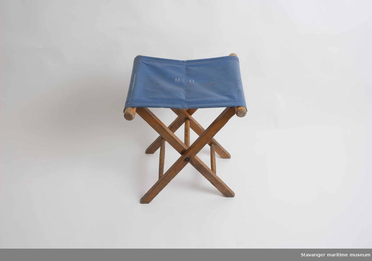 Klappstol i tre med blått plast sete, har også DSD logo på setet.