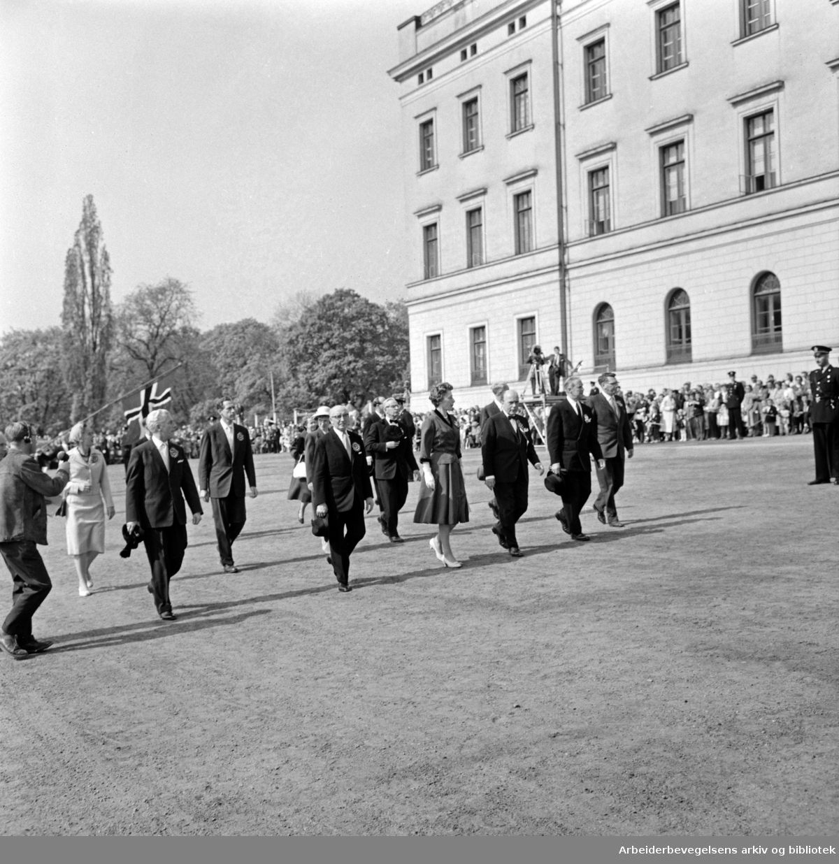 17. mai-komiteén fotografert utenfor slottet. Blant andre: Olav Brunvand, Brynjulf Bull, Rolf Stranger, Eva Kolstad og Olaf Solumsmoen. 17. mai 1960.