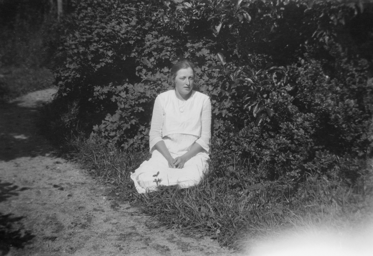Portrett av ukjent kvinne, sittende i gresset