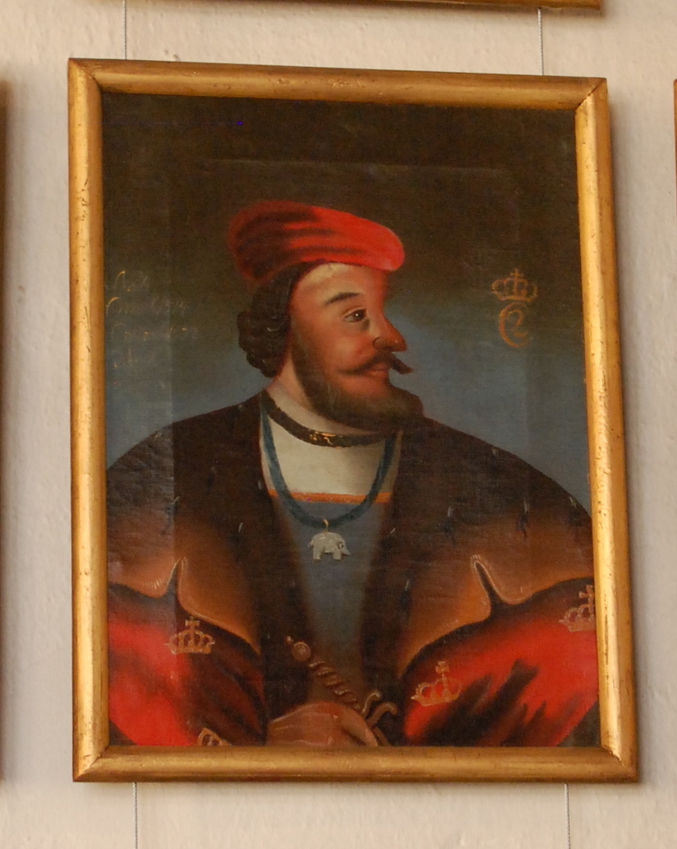 Portrett av Christian II. Olje på lerret. Halvfigur en face, hodet i profil mot høyre. Rød kappe med gullkroner og brun pelskrave. Elefantorden rundt halsen, rød lue.