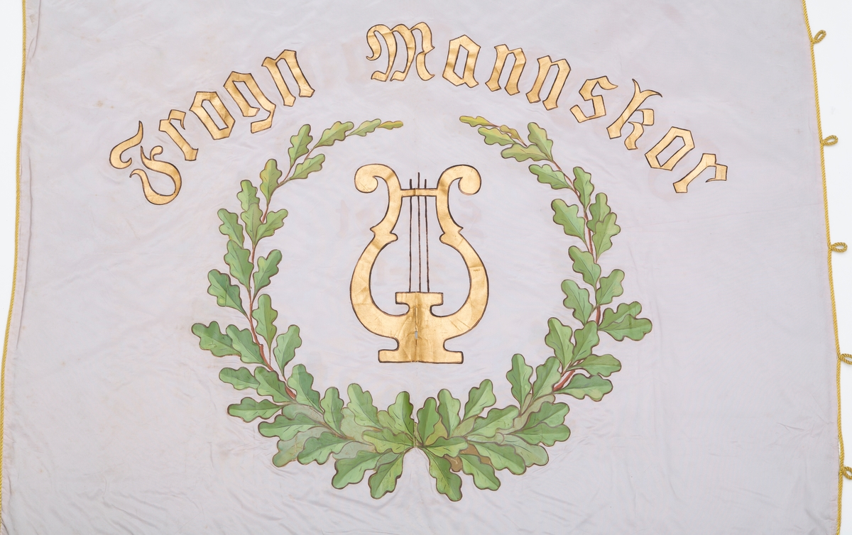 Lyseblå banner med eikebladmotiv. Gule frynser, bardunsnor og dusker.
A. Banner
B. Styresnor
C. Bardunsnor
D. Bandolær
E. Bærestang (topp del)
F. Bærestang (nederste del)
G. Råstang