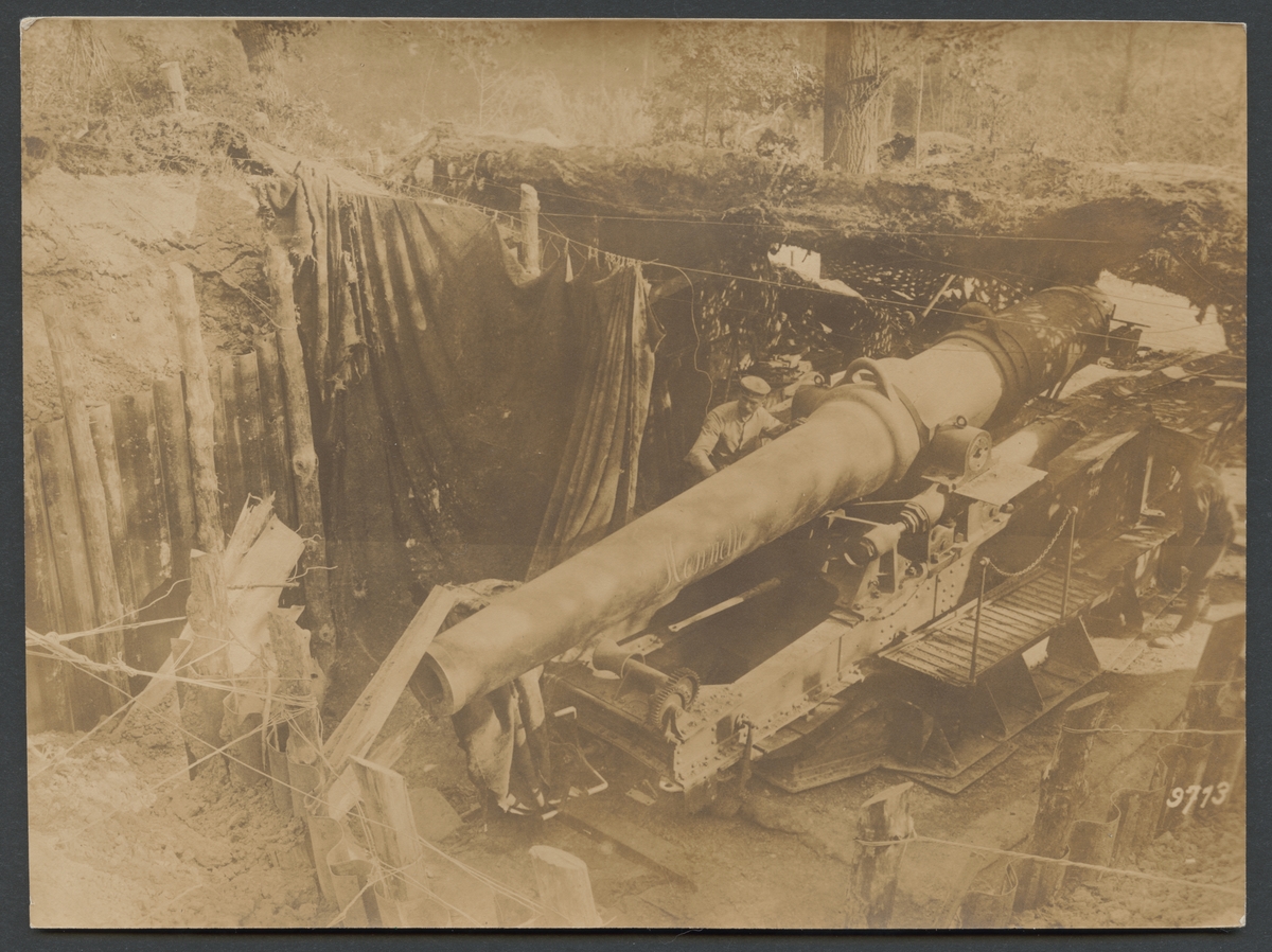 Bilden visar två soldater som undersöker en tung fransk artilleripjäs i en maskerad artilleriställning. Kanonen döptes enligt påskrift på eldröret på namnet "Henriette".