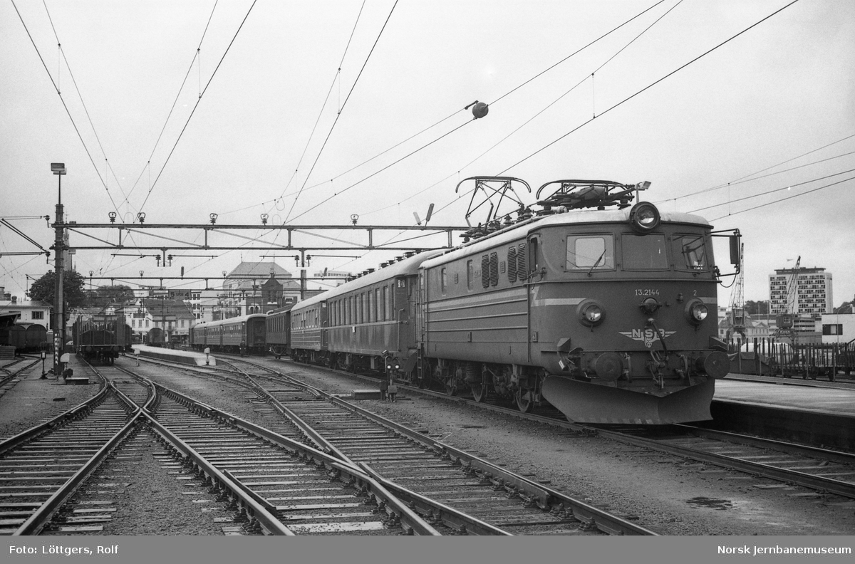 Elektrisk lokomotiv El 13 2144 med dagtoget fra Stavanger til Oslo V, tog 702, på Kristiansand stasjon. Ekstra vogner kobles til toget