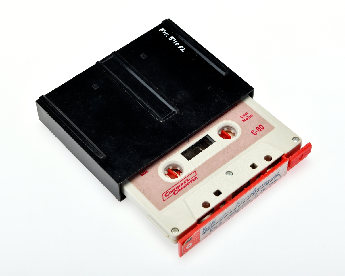 En rød opptakskassett i svart etui med opptaket "Kjøtt som kundemagnet". Etuiet har et klikk-system for å få kassetten ut av etuiet.