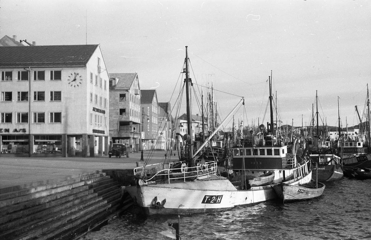 Avfotografert bilde fra et bryggeområde der fiskeskøyter ligger til kai. Stedet er muligens Kristiansund.