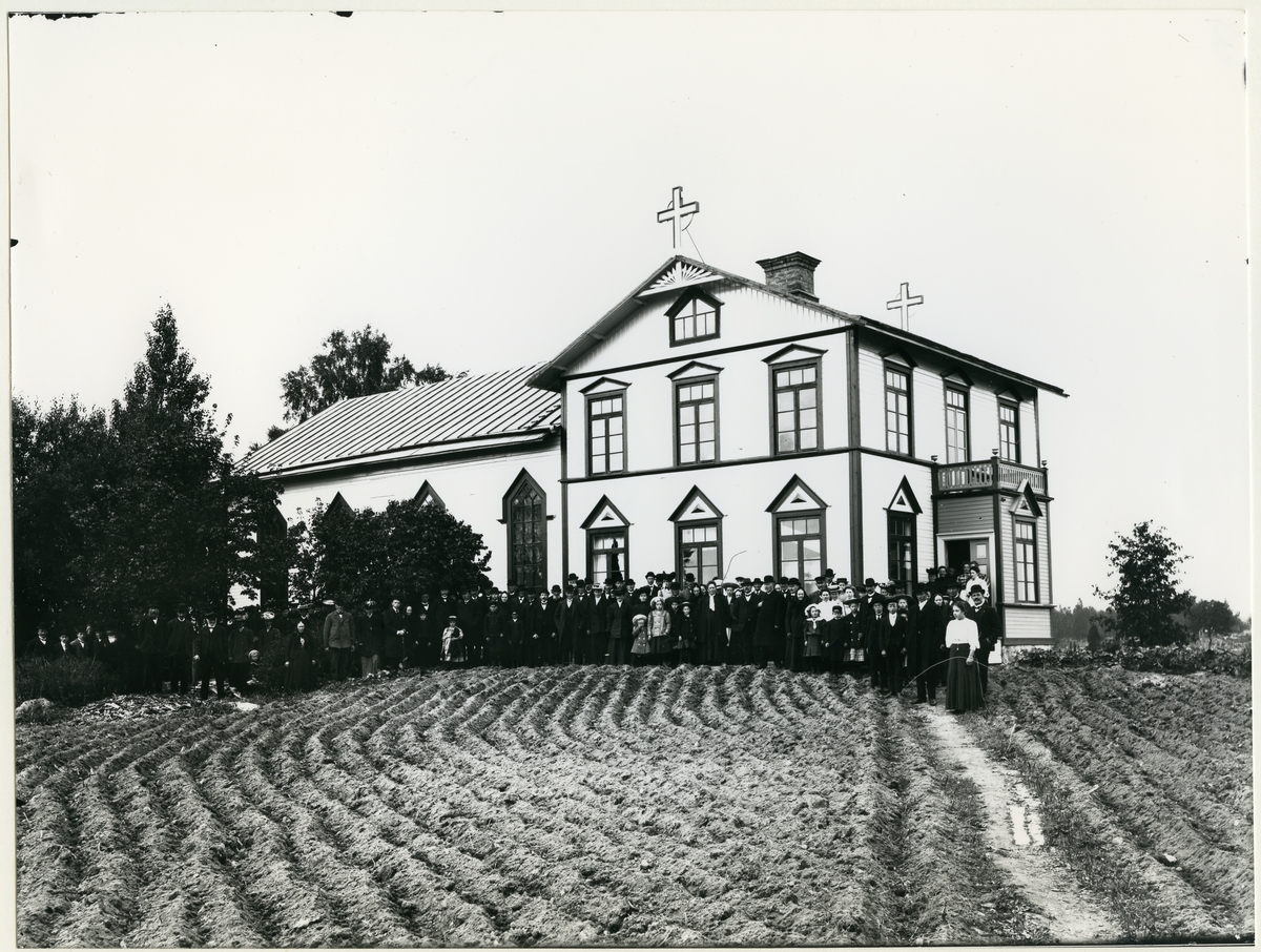 Möklinta sn, Sala.
Exteriör av Missionskyrkan med många församlingsmedlemmar stående utanför, c:a 1910.