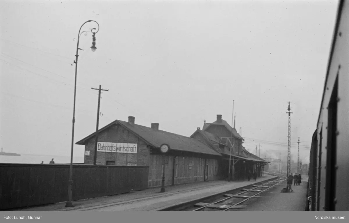 Motiv: Tyskland, Kurfürstendamm (Berlin);
En man bär en reklamskylt om halsen.

Motiv: Tyskland, Kurfürstendamm (Berlin), Sassnitz;
En man blåser i ett horn, skyltfönster med en skyltdocka, gatuvy på kvällen med upplysta skyltfönster.