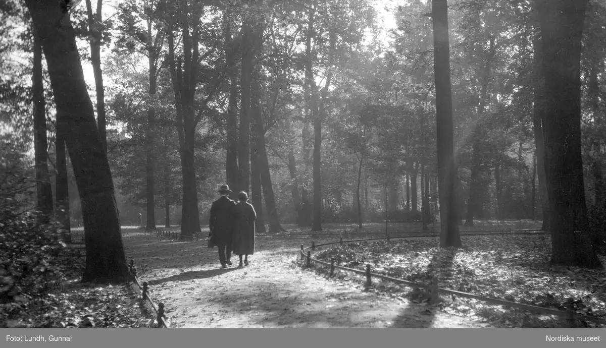 Motiv: Utlandet, Bad v. Berlin 147 - 156, Berlins Omgivningar 157 - 177 ;
En man och en kvinna går på en väg i en skog, anteckningar på kontaktkarta 156 "Badbild" 158 "Näckrosdamm detalj".