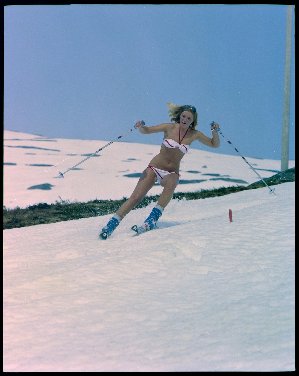 En ung kvinne står på slalom i bikini.