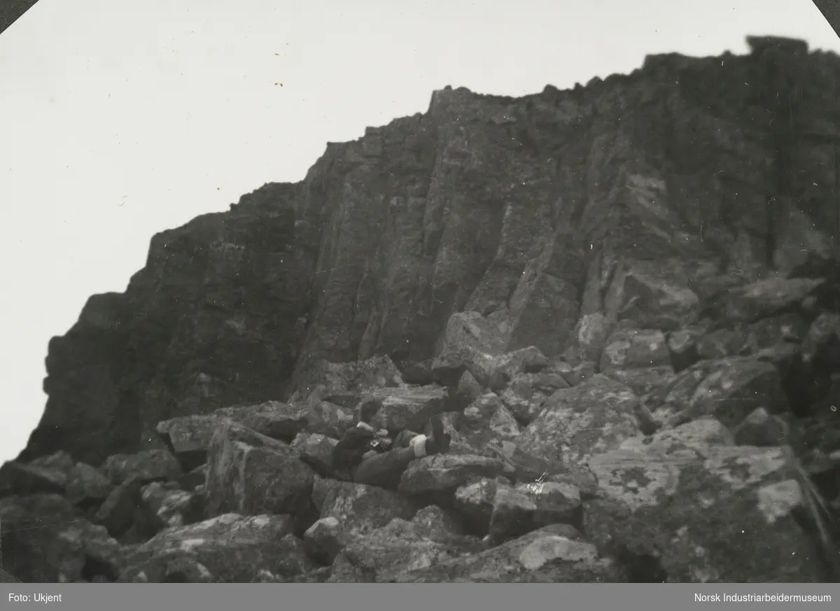 Anne Dyrland ligger på steiner i fjellet på Juvik, Møsstrond