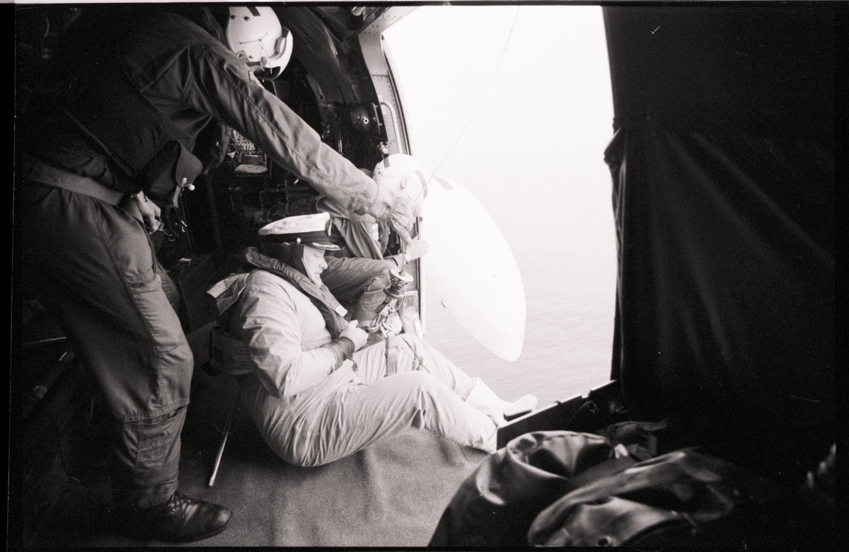 Marineoffiser heises ombord i et helikopter.