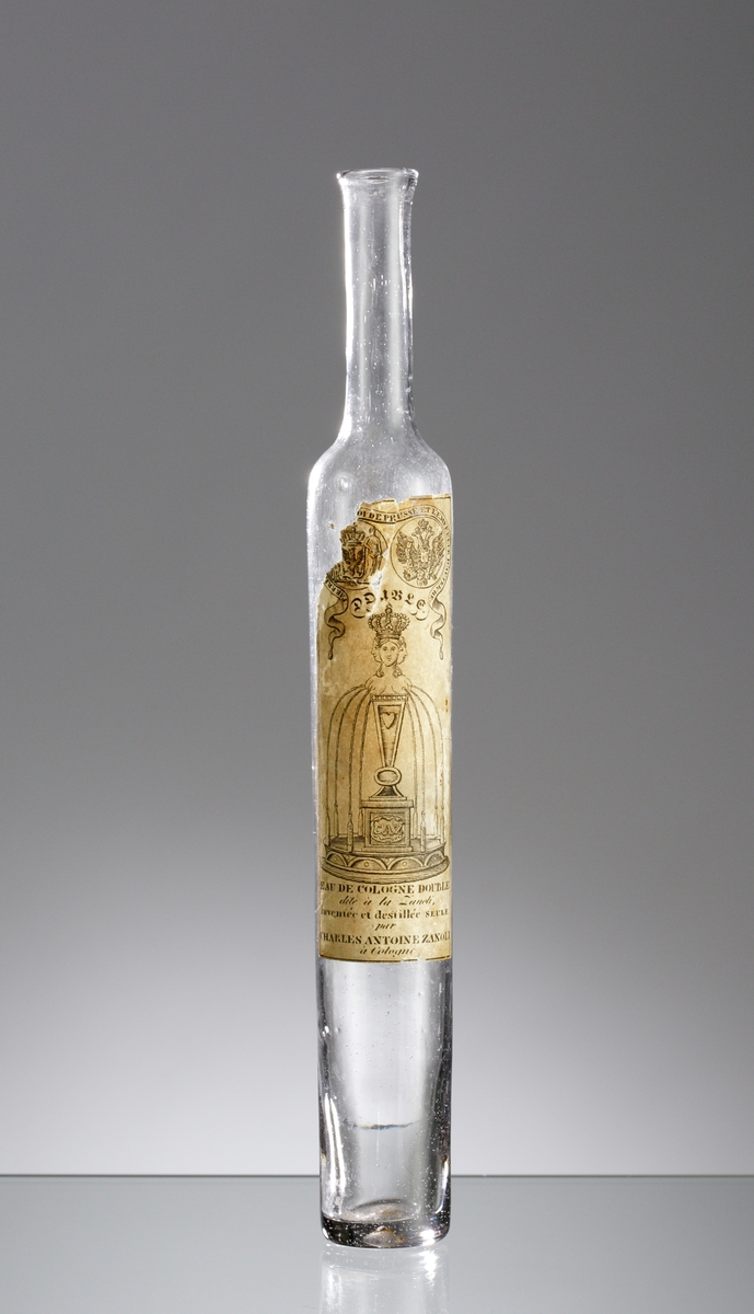 Flaska för Eau de Cologne tillverkad i Frankrike omkring 1800.
Fabriksmärke av papper med fantasirikt motiv.