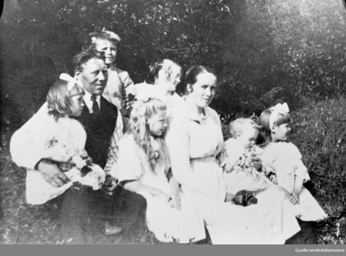 Mann, kvinne og seks barn, bildet er tatt i en skogkant?, det er sommer. 