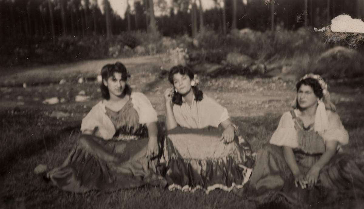 Tre romska kvinnor sitter på en äng i Hofors, 30 juli 1950.
