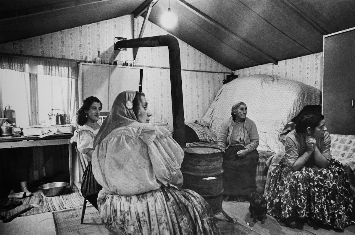Några kvinnor sitter tillsammans i ett hem byggt av masonit. Lägerplatsen Ekstubben låg i Skarpnäck söder om Stockholm, i nuvarande Flatens naturområde, på en plats där det i dag ligger en motorbana.