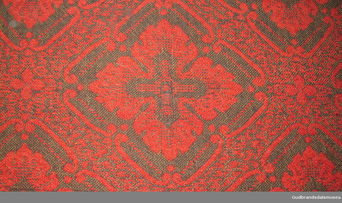Åkle - i jaquardvev. En form for dobbeltvev. Teppet har samme mønster på begge sider. Farge rødt og sort. Sydd sammen av to like deler. Veven er så avansert at det brukt hullkort.