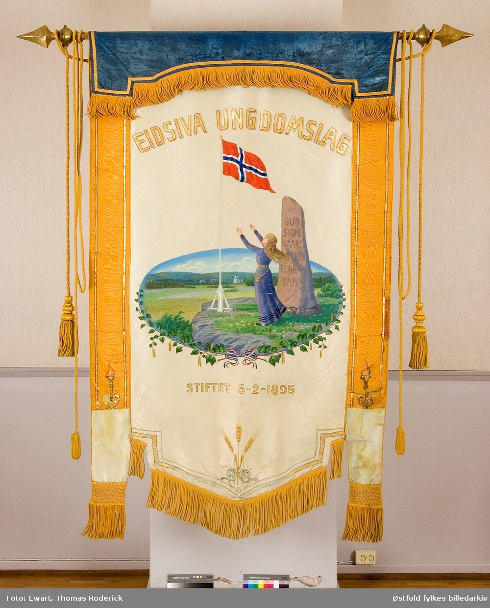 Fane til Eidsiva Ungdomslag stiftet 3. februar 1895. Forside og bakside.
Påskrift på bauta i motiv:  Gud signe vaart dyre fedreland.