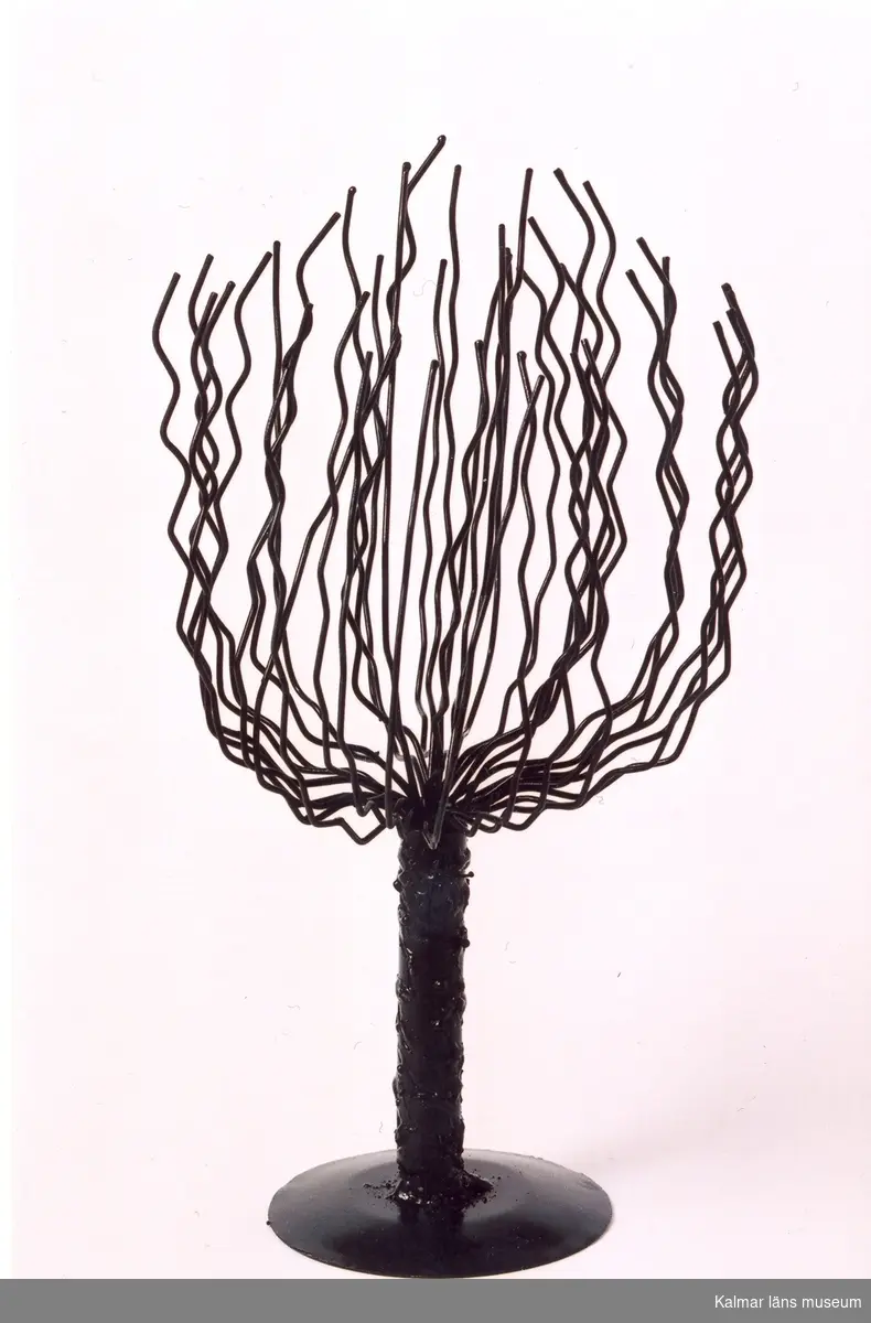 KLM 39586:34. Prydnadsföremål/skulptur i form av stiliserat träd av metall och ståltråd, svartmålad. Tillverkad i konstsmide/trådarbete, svetsad. Tillverkad av trådslöjdare Yngve Axtelius.