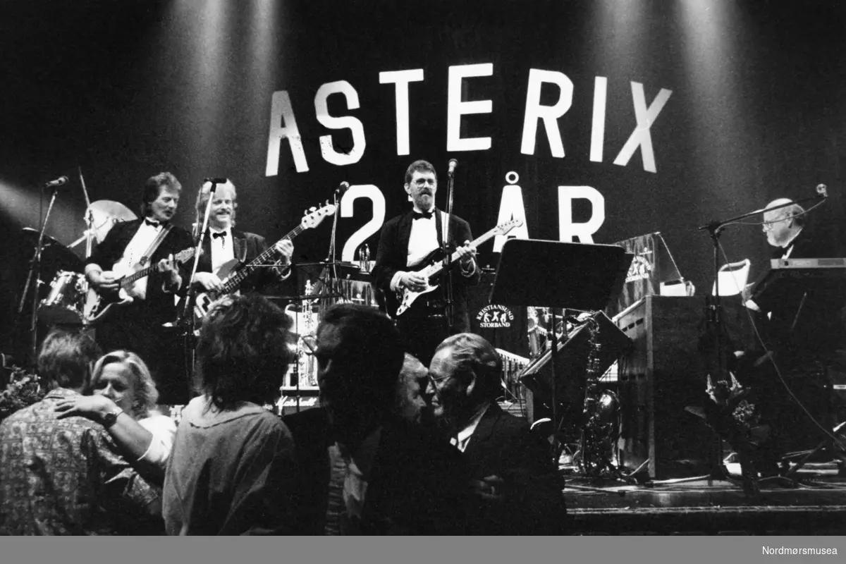 Musikkbandet Asterix    - .ASTERIX 
Dette bandet startet som en trio i 1968, og det var også året da den franske tegneserien Asterix ble presentert for norske tegneserielesere i Tempo. Asterix ble raskt en populær serie, og for Geir Sakshaug & co var det fristende å velge samme navn. 
Historien til bandet er lang, hele 48 år. Asterix spilte sin siste dans i 2016. For målet til Asterix har hele tiden vært å spille god musikk som folk ville danse til. Og det har de gjort fra Oslo i sør til Inderøya i nord. Asterix har spilt på alt fra labbdans på ungdomsskolene til engasjement som har vart i ukevis på en eller annen danserestaurant. Bl.a. var Asterix husorkester ved Surnadal Hotell sju påsker på rad. 
Den på mange vis klassiske besetningen med Geir Sakshaug (tangenter), Svein Lauritzen (gitar og sang), Jarl Hennøen (gitar og sang), Arve Lyngstad (bass og sang) og Martin Hermundsli (trommer) eksisterte fra 1978 til 1992. De ga også ut en single i 1981, «Æ og du/Bli med ut». 19 år senere, i 2000, ga de ut en CD, «30 år på veien …». Da hadde de knyttet til seg Per Arne Westavik og Ove Borøchstein som kreative tekstforfattere.
I tillegg til de medlemmene av bandet som er nevnte, er det også flere gode musikere som har tjenestegjort i kortere eller lengre tid i Asterix: Alf Ekholm, Arve Sørdal, Bjørn Ersvik, Svein Råket og Roy Bøe, for å nevne noen. Men sist, men ikke minst, er det viktig når man snakker om Asterix å ta med at de har hatt tre meget markante kvinnelige vokalister i sine rekker – Eva Peggy Stensønes, Lynni Treekrem og Inger Lise Bøe.  Tekst: Bjørn Skarsem. 
 Bildet er fra avisa Tidens Krav sitt arkiv i tidsrommet 1970-1994. Nå i Nordmøre museums fotosamling.