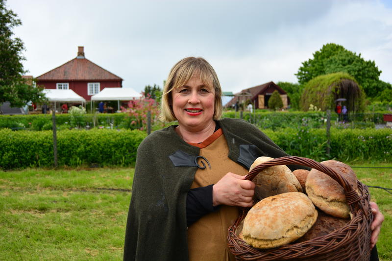 Kvinne med kurv full av runde brød over armen. (Foto/Photo)