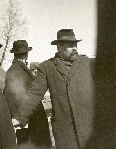 En medelålders man med stora mustascher, klädd i rock och hatt. 
Till höger rubrik: "- STUDIERESAN -".  Under fotot text: "- Fille -".