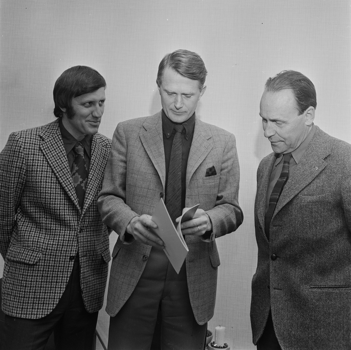 Tre män läser en broschyr, Tierp, Uppland, april 1972