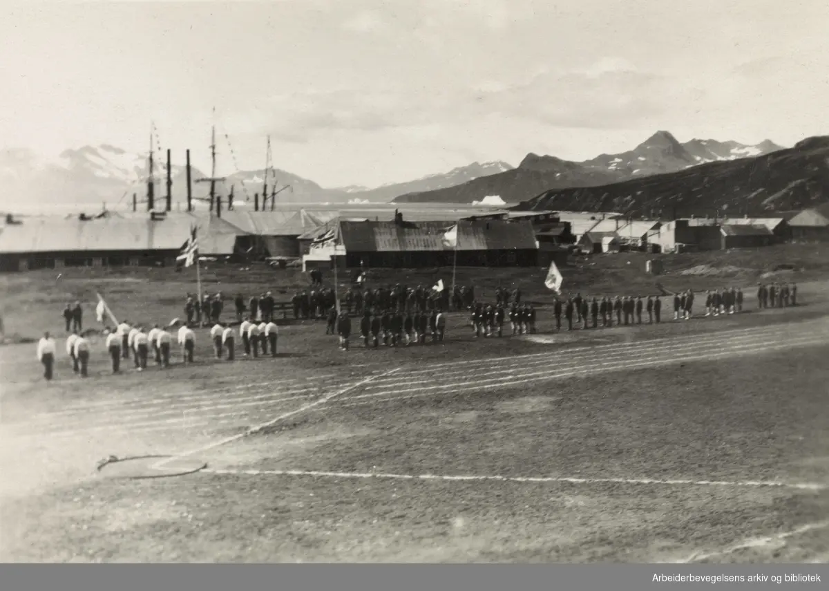Hvalfangere på land arrangerer mini-olympiade på Sør-Georgia, 1930-årene. Idrettsparade. Norske og engelske flagg..