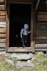 Liv i stuene 2016. En ung gutt, kledd anno 1900, står i en dørterskel.