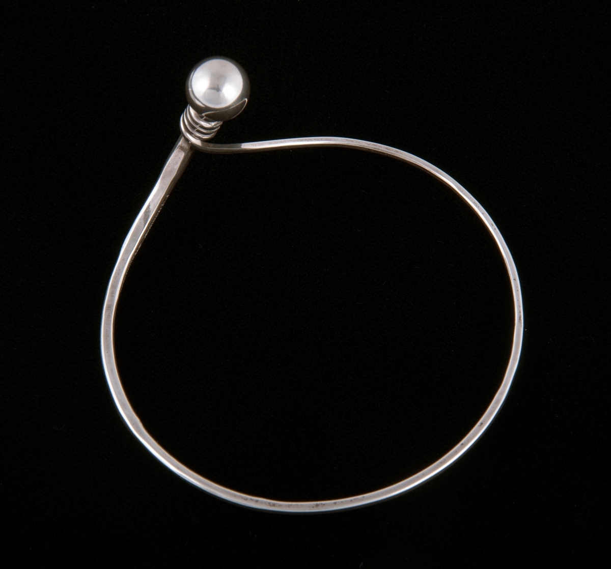 Består av en sølvtråd som avtar i bredde fra ende til annen. Endene forenes til en ring som markeres med en sølvkule. Kulen og endene er bøyd ut i vinkel fra armringen. 
