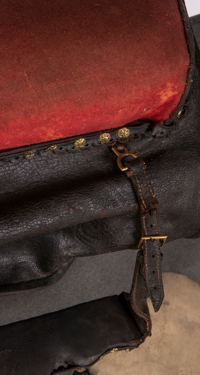 Trukket med rødt klede og sort skinn.
Nagler og dyrehode av messing.
Gjennomskåret og sydd: SJDM 1794