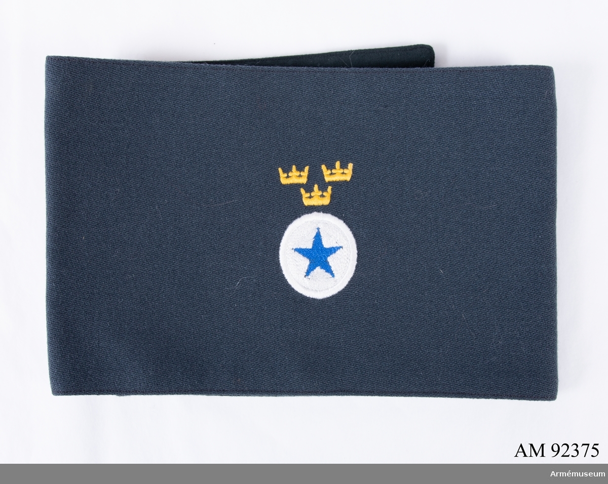 Armbindel sydd i mörkblått bomullstyg med Svenska Blå Stjärnans märke.