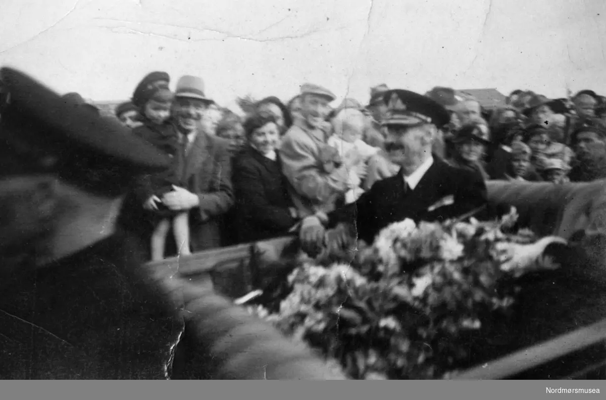 Foto av Hans Majestet Kong Haakon VII på besøk, trolig på Frei, nå i Kristiansund kommune. Fra fotoarkivet etter portrettfotograf Claus Monge. Nordmøre museum overtok samlingen fra sommeren 2011.
