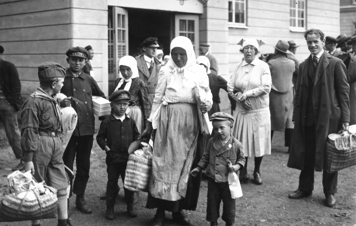 Svenskbyborna och deras ankomst till Jönköping år 1929. De blir inkvarterade vid I 12:s gamla förläggningslokaler på Ryhovsområdet och blir hjälpta av scouter och lottor.
