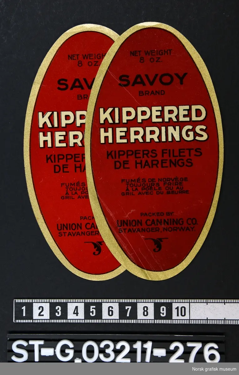 Ovale etiketter i rødt med ramme i gull og tekst i sort og hvitt. 

"Kipperered herrings
Kippers filets de harengs"