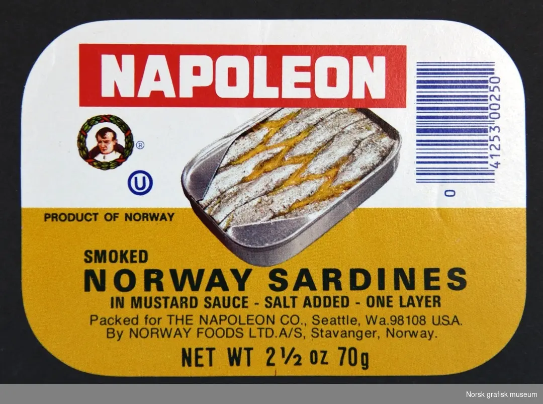 Etikett med hvit og sennepsgul bakgrunn. Midt på er en fremstilling av en åpnet hermetikkboks. 

"Smoked Norway sardines in mustard sauce"