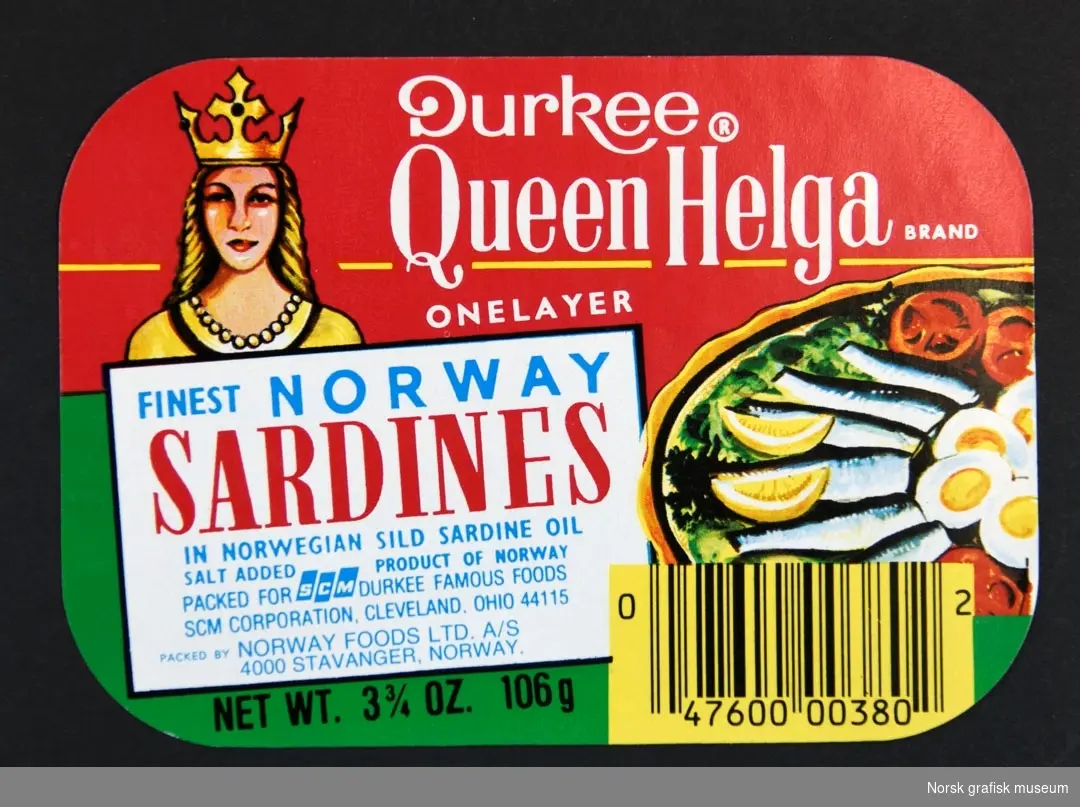 Etikett med rød og grønn bakgrunn, en blond kvinne med krone ses over varebeskrivelsen i en hvit ramme. Til høyre er en illustrasjon av et fat med sardiner, egg, sitron og tomat. 

"Finest Norwegain sardines in Norwegian sild sardine oil"