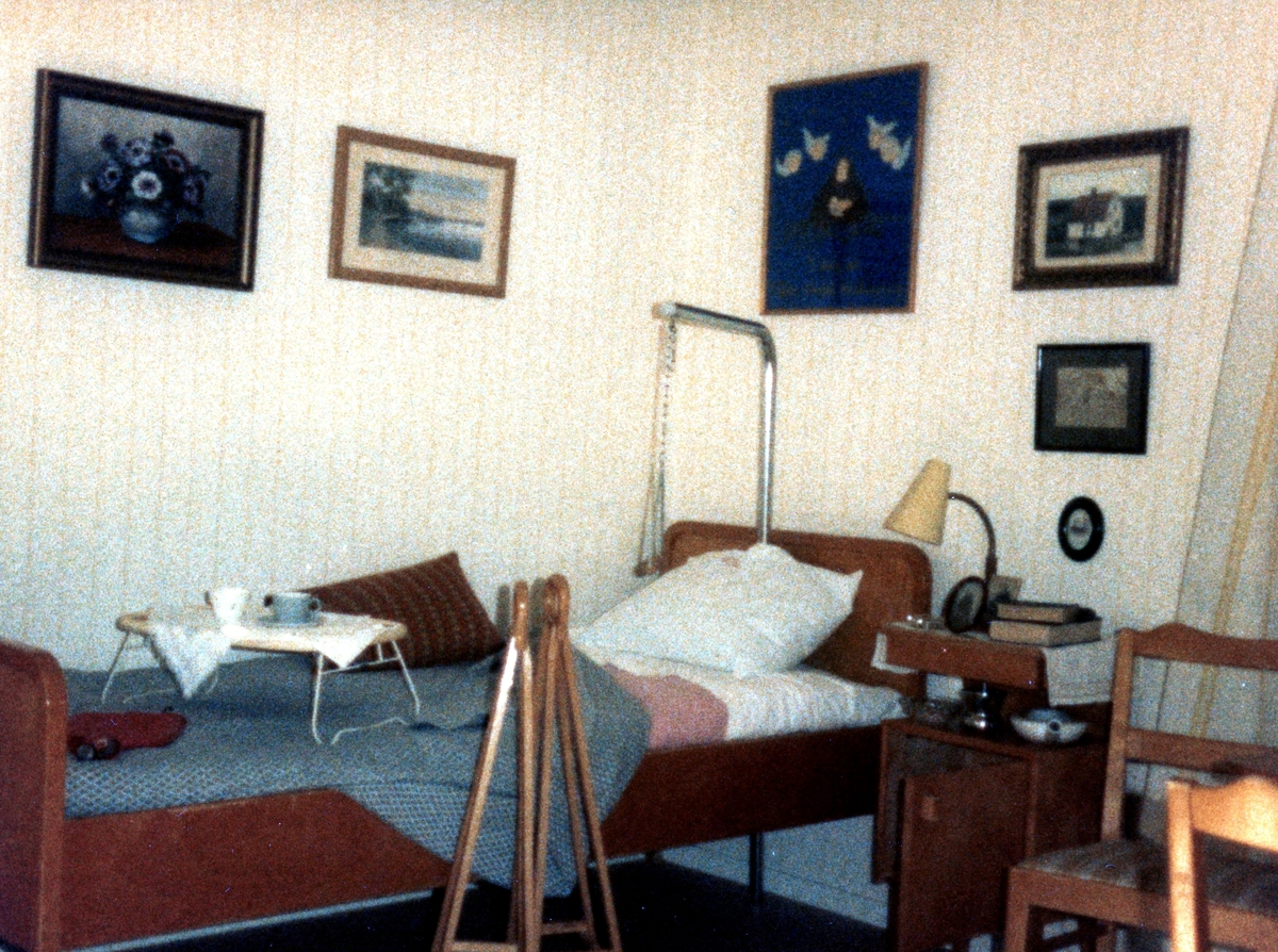 Brattåsgården vid invigningen år 1986. Utställning av föremål från gamla Brattåshemmet, gjord av Kållereds Hembygdsgille. Delar av föremålen finns nu på Mölndals stadsmuseum. Här ses en säng, sängbord och tavlor.