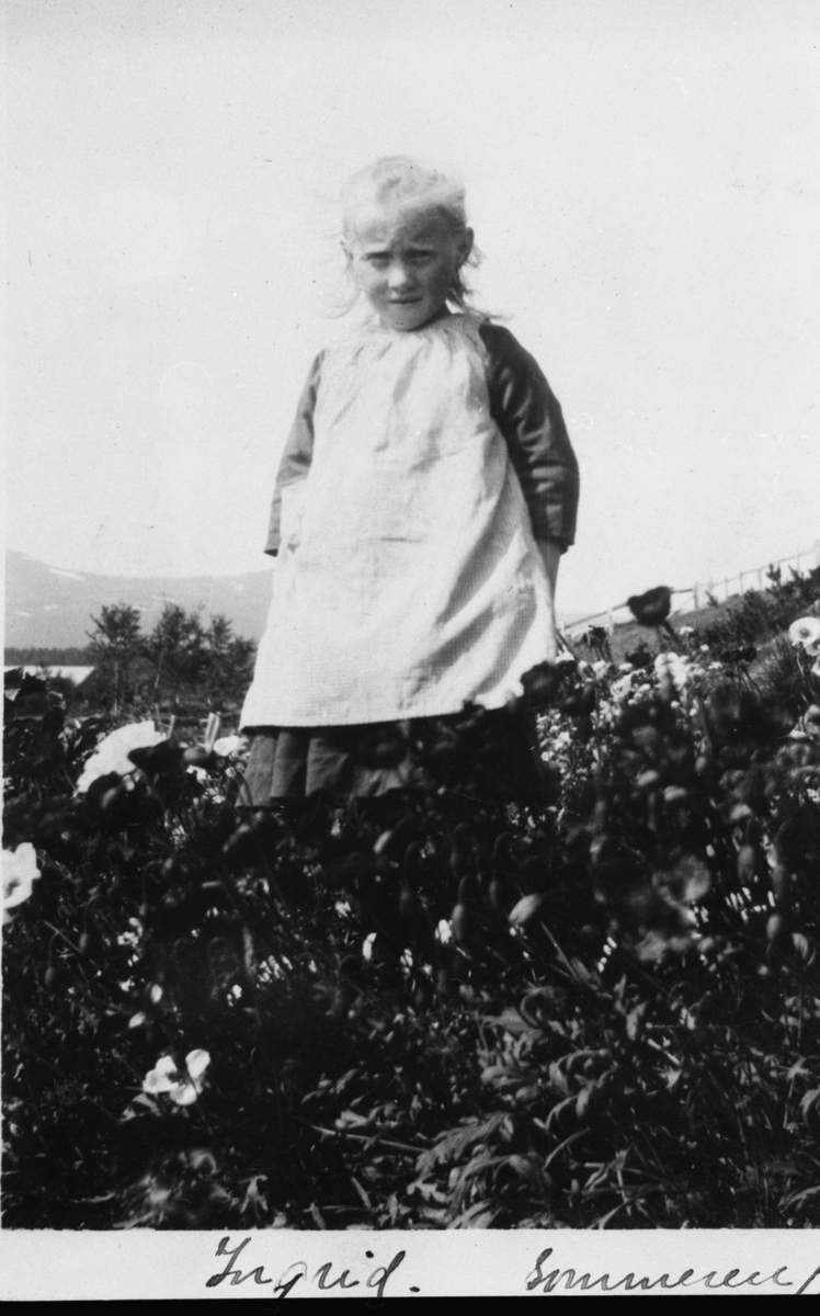 Ingrid Solveig Gjelten (17.11.1915-8.2.1991) plassert i et blomsterbed i Sima O. Gjeltens hage.