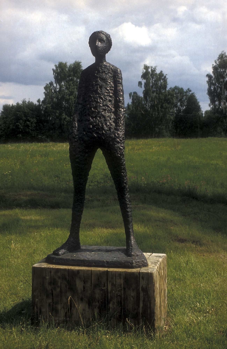 Skulpturen fremstiller en ung pike som står bakoverlent.
