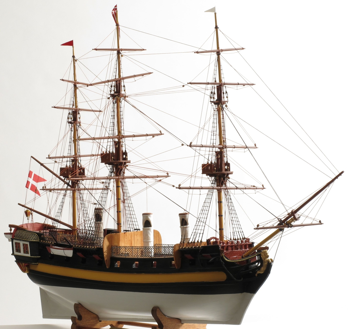 Modell av handelsfregatt og slaveskip Fredensborg, bygd etter skutebilde og studier av skipstypen. Skipet har tre master, rær på alle.  Alle deler er laget av modellbyggeren.