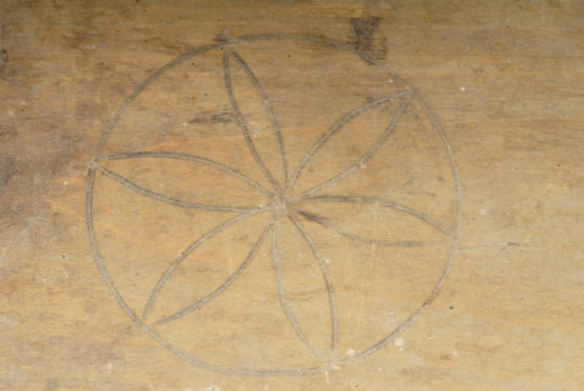 Skakekniv av tre med graverte motiver av sirkler og blomster.