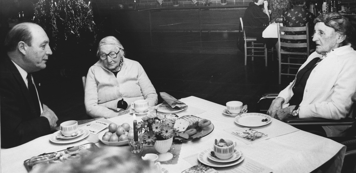 Ordfører Rønold Haugen ved kaffebordet med to eldre kvinner.