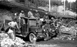 Gamle lastebiler og veiarbeidere på arbeid i grushålen på Yt