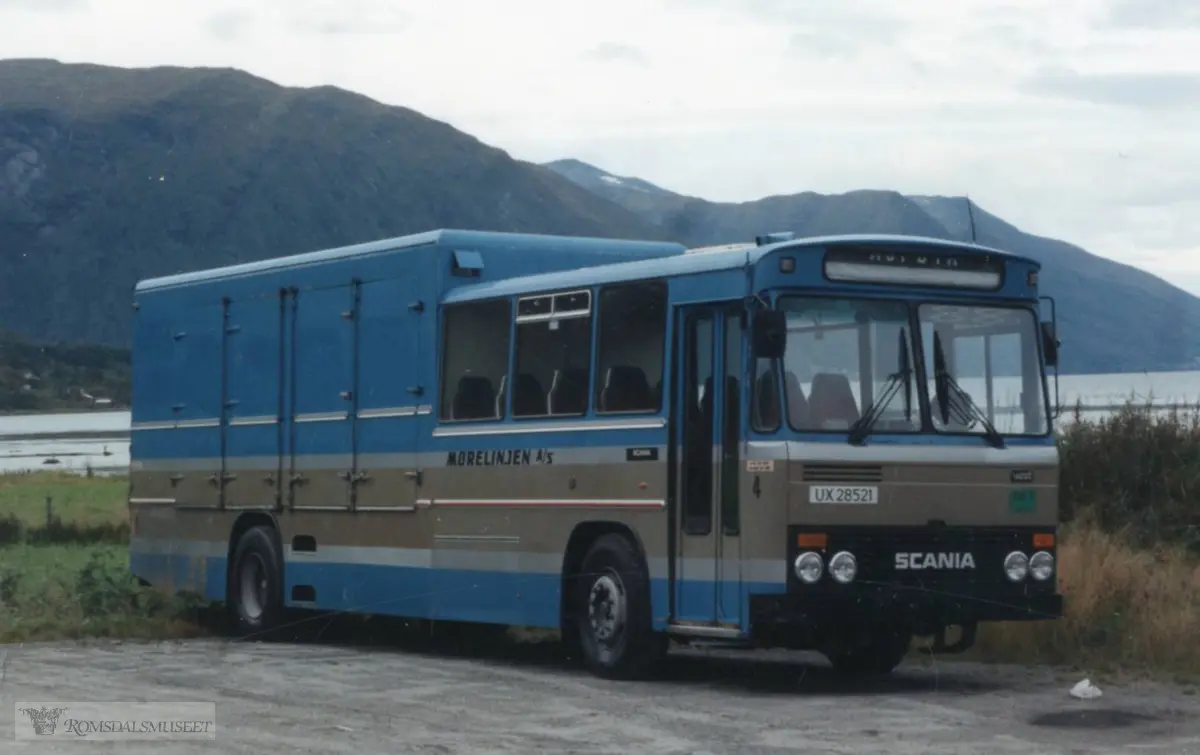 Mørelinjen A/S..UX28521 var en Scania BF111S63 kombinertbuss, 1982-modell, levert ny til Kristiansund-Oppdal Auto (KOA). Den hadde 16 sitteplasser og stort godsrom. Det var flere sammenslutninger av rutebilselskaper på 1980-tallet, og fra 1988 ble firmanavnet Mørelinjen A/S. Bussen var i rutebiltrafikk i ca. 20 år og deretter solgt til nye eiere. Den ble avregistrert høsten 2017..(fra Oddbjørn Skjørsæter sine samlinger i Romsdalsarkivet)