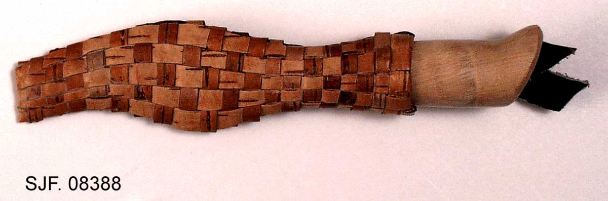 Slirekniv, lagd av Erik Godtman fra byen Åmål i Västra Götalands län i Sverige. Han har brukt et fabrikkprodusert blad fra Frost i Mora i Dalarne. 

Kniven er 19,5 centimeter lang, målt fra bladspissen til den bakre enden av skaftet. Bladet er av den laminerte typen, med en kjerne av forholdsvis hardt eggstål omgitt av noe smidigere jern. Det er 9,5 centimeter langt. Bredden bakerst, ved innskjeftinga, er 1,8 centimeter. Tjukkelsen på bladet, målt samme sted, er 2,7 millimeter. Den bakre delen av bladryggen er rett, men den fremre, i cirka 4 centimeters lengde, er slipt slik at den skrår noe nedover mot bladspissen. Høyre bladside er stemplet i «Frosts  MADE IN SWEDEN  LAMINATED STEEL». Skaftet er lagd av et treslag med forholdsvis lys ved. Det tiltar i bredde bakover, der skaftbuken avsluttes med en liten krok som knivbrukerens lillefinger kunne ligge an mot. Den fremre enden av skaftet er forsterket med en cirka 1 centimeter bred blikkholk. I den bakre skaftenden, som er skråskåret, er enden av «tangen», jernteinen som i forlengelsen av knivbladet er tappet gjennom den sentrale delen av skaftet, stuket mot ei lita kobberskive.

Slira er flettet av 5-7 millimeter brede neverstrimler. Den er 16,6 centimeter lang og har svungne sidekanter. Tverrsnittet i den øvre enden, som skal omslutte den fremre delen av knivskaftet, har et ovalt tverrsnitt. Den nedre delen, som beskytter bladet, er mer flattrykt. Inni den nedre delen av slira har knivmakeren lagt ei lita treskie, antakelig for å forebygge at flettverket skades når kniven stikkes ned i slira. På baksida av sliremunningen er det innknyttet et oppheng av brunfarget lær.