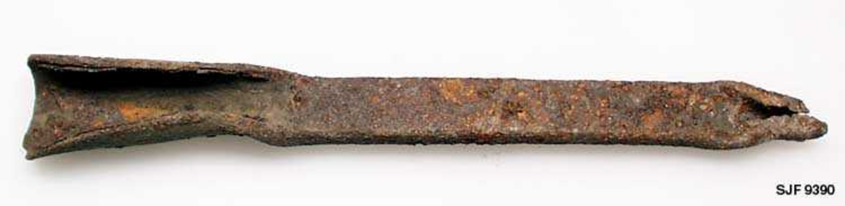 Denne gjenstanden er fra smia til Svein Svimbil (1888-1987) i Tinn i Telemark, som ble overlatt til Norsk Skogbruksmuseum i Elverum i 1991 og gjenoppført på museet året etter. Den ble innregistrert i museets katalig som «knivbladholder» - antakelig ut fra en oppfatning om at dette var et hjelperedskap Svimbil hadde brukt under knivsmiinga. . Gjenstanden er 19,7 centimeter lang. Den er smidd av ei jernstang med 7 X 16 millimeters tverrsnitt. I ytterendene er det smidd faler, den ene smal (1,0 centimeter i front), den andre bredere (2,6 centimeter). Gjenstanden er rusten.