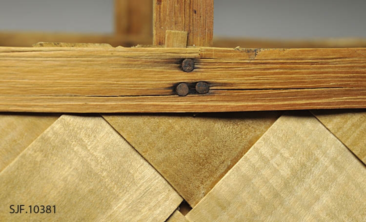 Sponkurven er skråflettet, og har en bøyd hank. Sponene er jevnbrede, og er maskinhøvlet.

Bunnen har en rektangulær form. Sponene er vikt opp, og sidene er rette. 
Kanten danner en form tilsvarende bunnen. På kanten er det lagt på et smalere spon på hver side som er festet med metallstift. 

Innvendig og utvendig skjøt ligger på hver sin kortside.
Hanken ligger på innsiden av de flettede sidene, og er festet mellom flettet side og indre kantspon. Hanken består av et tykkere spon som delvis er kløyvd i to. Spiker og stifter i kurvkant er rustne.

Kurven har tydlige spor etter jordslag. 

Det ligger et dobbelt gråpapir i bunnen på kurven.
