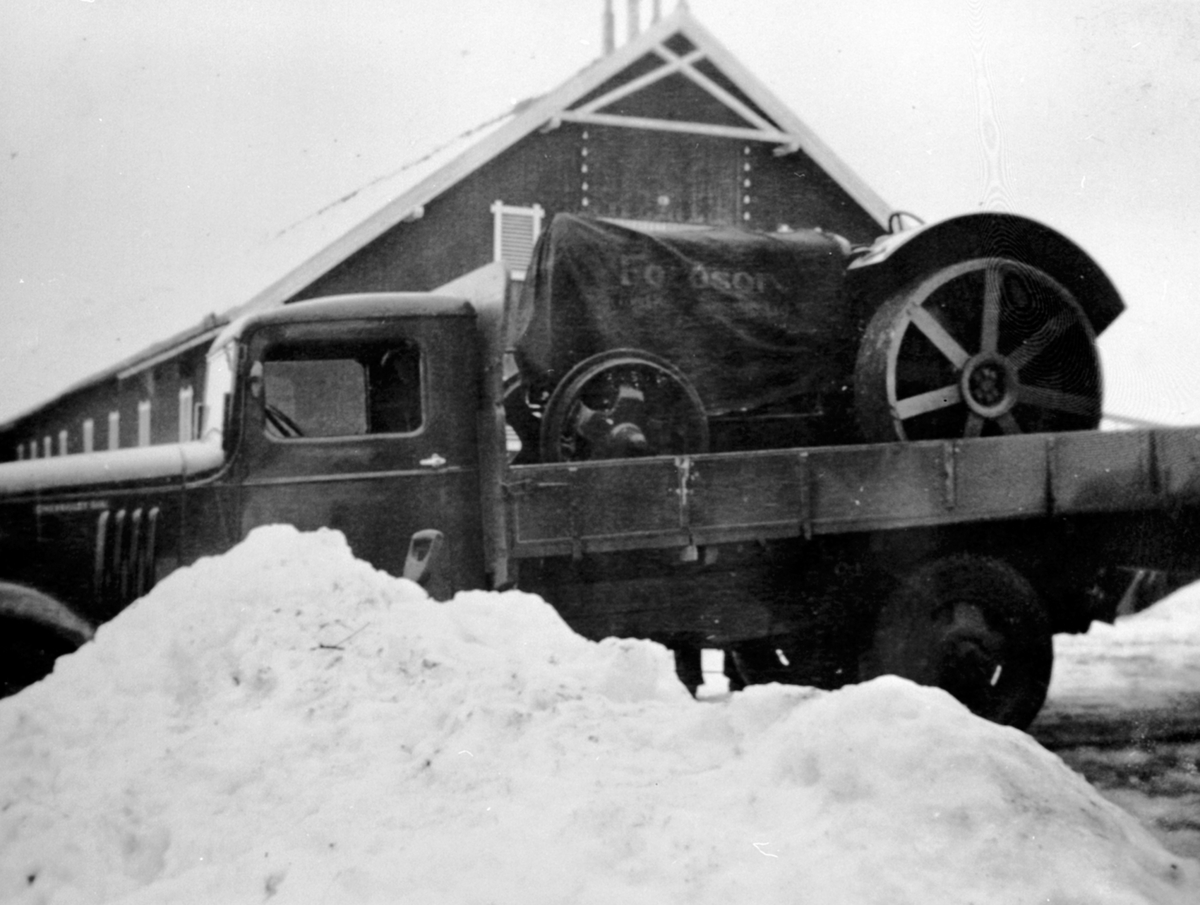 Ny Fordson jerntraktor kommer transportert på lastebil til Tørud gård, Ringsaker. Lastebilen er en Chevrolet 1934-35 modell.
